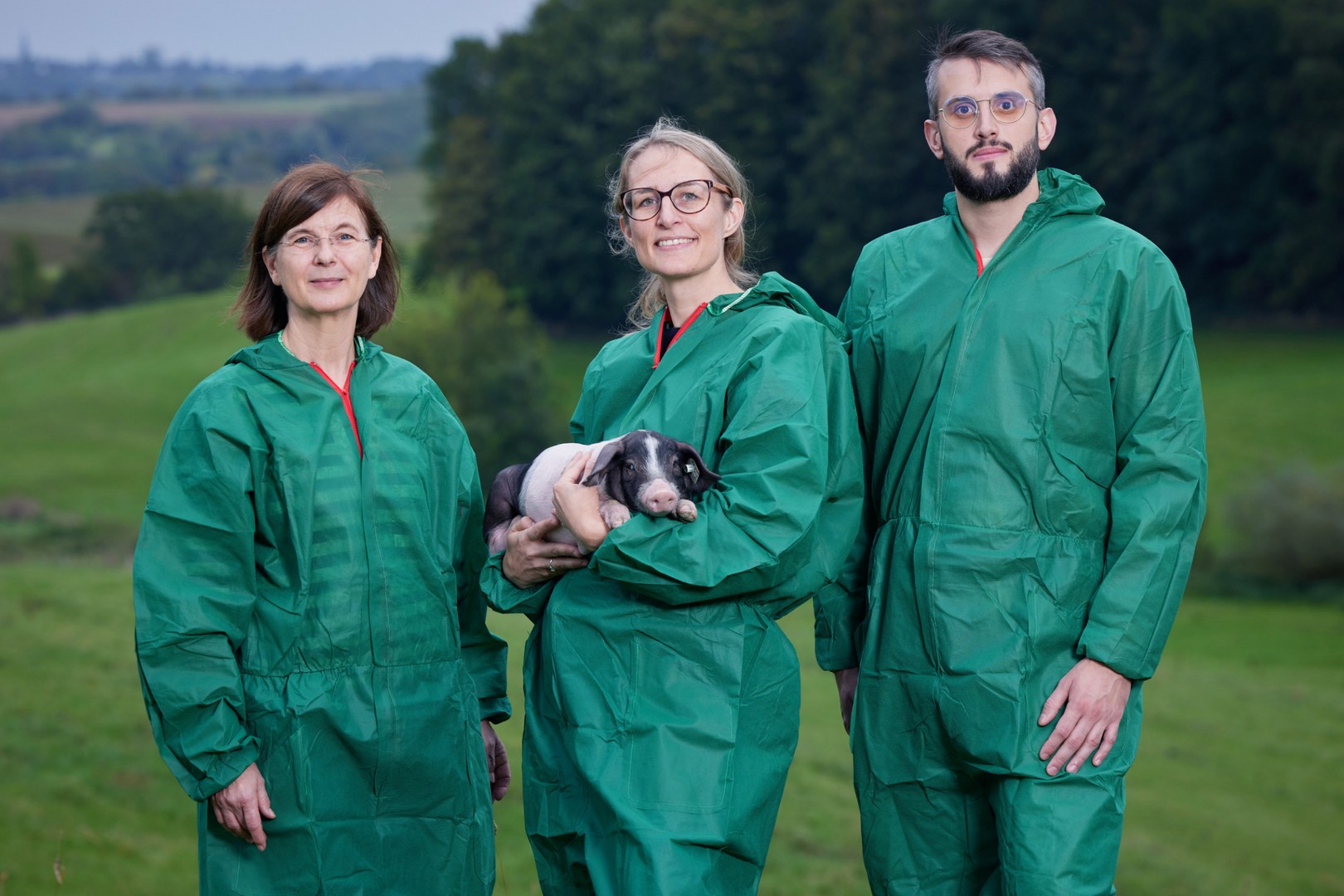 Das Team (von links) in Hygiene-Schutzkleidung und mit Ferkel