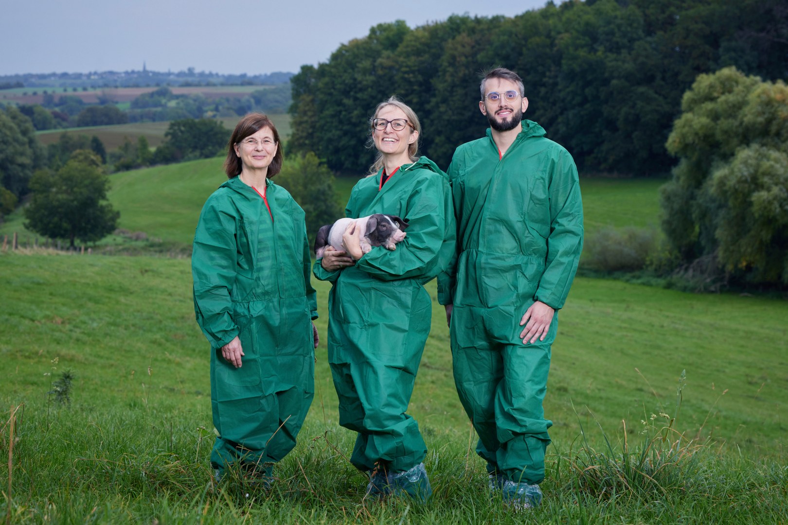 Das Team (von links) in Hygiene-Schutzkleidung und mit Ferkel