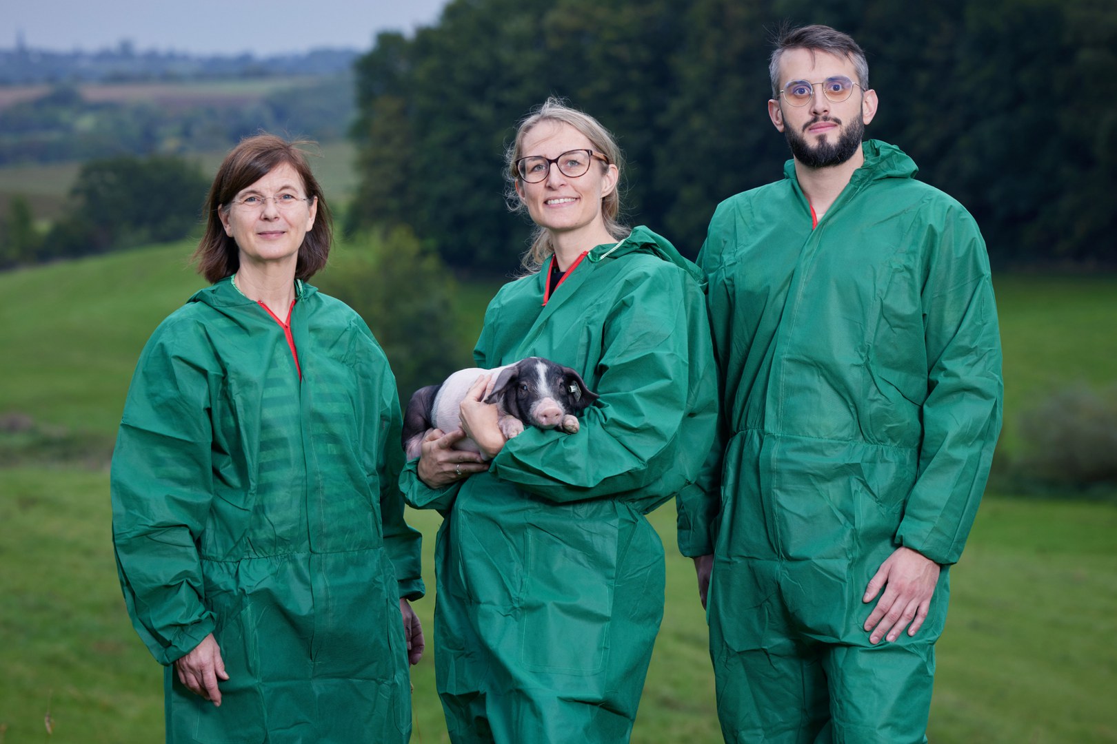 The team (left to right) in hygienic protective clothing with a piglet: - Prof. Dr. Monika Hartmann, Jeanette Klink-Lehmann and Milan Tatic at the Frankenforst Campus in Vinxel in the Siebengebirge region.